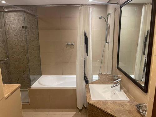 bagno con vasca, lavandino e doccia di Modern 2BR Apart DIFC Downtown World Trade Center a Dubai