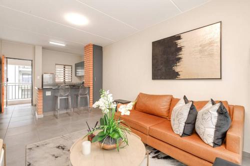a living room with a couch and a table at Waterfall Ridge - Retreat in the heart of Midrand in Midrand