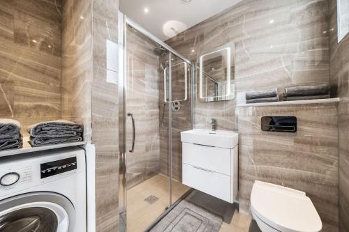 a bathroom with a washing machine and a toilet at Amazing One bedroom Penthouse in Wimbledon in London