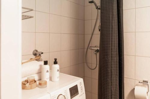 a bathroom with a shower with a microwave on a counter at 2-Bedroom, Steps from the Metro! in Helsinki
