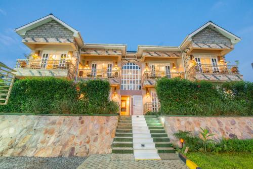 a large house with stairs in front of it at JET VILLAS ENTEBBE ( JVE ) in Entebbe