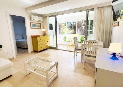 マルベーリャにある1 Bedroom Apartment Second Line Beach- Parque Marbella Buildingのリビングルーム(テーブル、椅子付)、キッチン