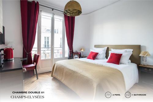 a bedroom with a large bed with red pillows at Beauquartier - Champs-Elysées in Paris