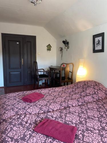 a bedroom with a purple bed with a table and chairs at Droom b&b Čermná in Čermná