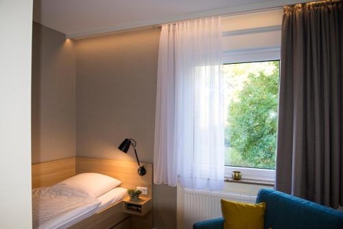 ein Schlafzimmer mit einem Bett neben einem Fenster in der Unterkunft Haus Mariengrund in Münster