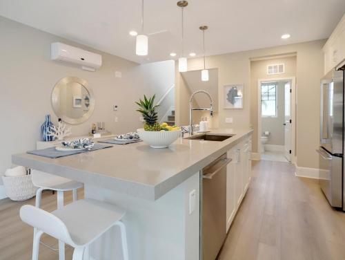 a kitchen with a large island with a sink and chairs at Bayside Cove 3 in San Diego