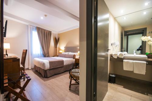 a hotel room with a bed and a bathroom at Le Petit Boutique Hotel in Santander