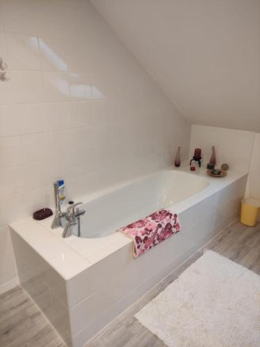 - une baignoire blanche avec lavabo dans la chambre dans l'établissement catherine zajac, à Saint-Nom-la-Bretêche
