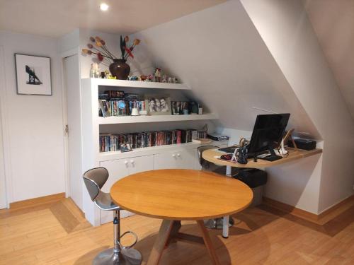 Zimmer mit einem Tisch und einem Schreibtisch mit einem Laptop in der Unterkunft catherine zajac in Saint-Nom-la-Bretêche