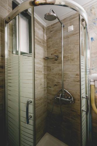 a shower with a glass door in a bathroom at Sagredo Traditional House in Nafplio