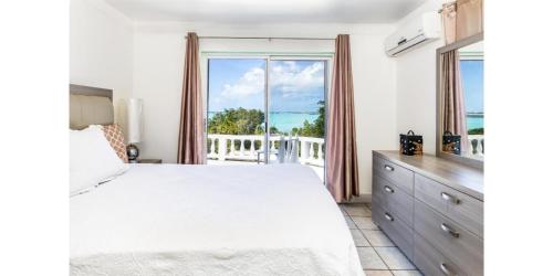 a bedroom with a bed and a large window at NEW Waterside Home Whirlpool Spa Tub Smart TV in Providenciales