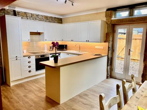 a kitchen with white cabinets and a counter with a sink at The Old Vicarage in Berwick-Upon-Tweed