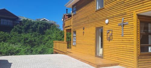 een houten huis met een veranda aan de zijkant bij 44 Nature On Sea in Groot Brak Rivier