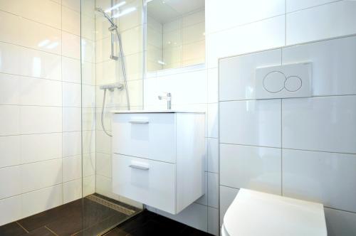 a white bathroom with a toilet and a shower at Vakantiepark Bosmeer Friesland in Noordwolde