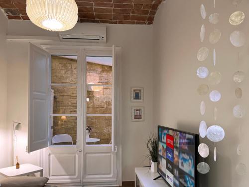 ein Wohnzimmer mit einem TV und einem Fenster in der Unterkunft CON GRACIA in Barcelona