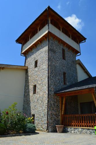 a large stone building with a wooden roof at Pensiunea Casa Buna in Gîrbova