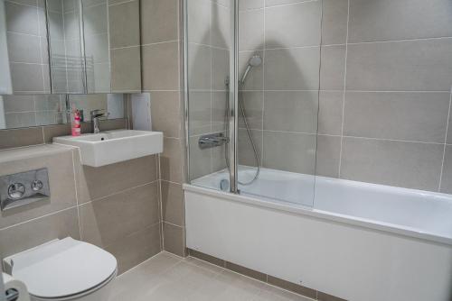 a bathroom with a shower and a toilet and a sink at Top floor Apartment in London