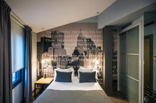 a bedroom with a bed with a wall with words on it at Le Petit Boutique Hotel in Santander