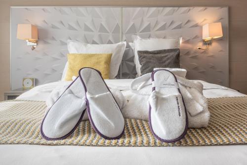 a pair of shoes sitting on top of a bed at Mercure Annecy Sud in Annecy