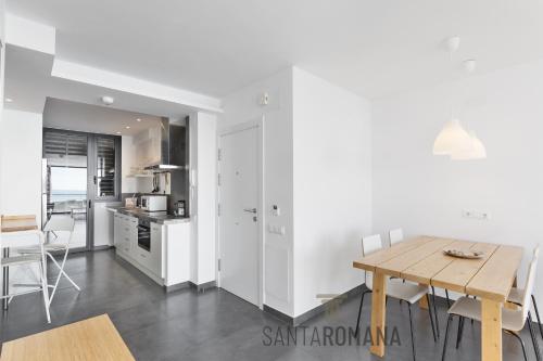 een keuken en eetkamer met een houten tafel bij Santa Romana Apartments & Suites in Caldes d'Estrac