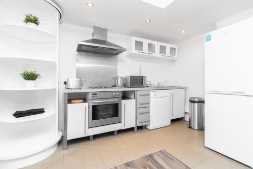 cocina con armarios blancos y fogones en Birmingham, City Centre - 2 Bedroom Apartment - Twin Beds - Secure Parking - Top Rated - 97Q, en Birmingham