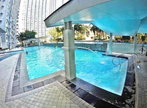a large pool with blue water in a city at The Grass Residences in Manila