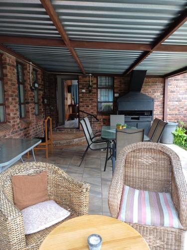 a patio with chairs and a table and a stove at Cura Lodge in Bloemfontein