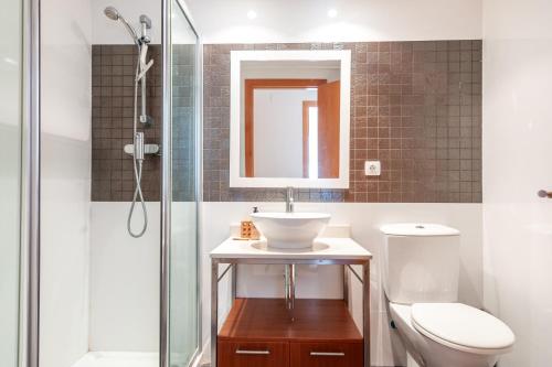 ein Bad mit einem Waschbecken, einem WC und einer Dusche in der Unterkunft Burriana Beach Retreat: Pool & Comfort in Burriana
