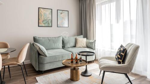 a living room with a couch and chairs and a table at Lion Apartments - SCALA City Center Apartments&Parking IA in Gdańsk