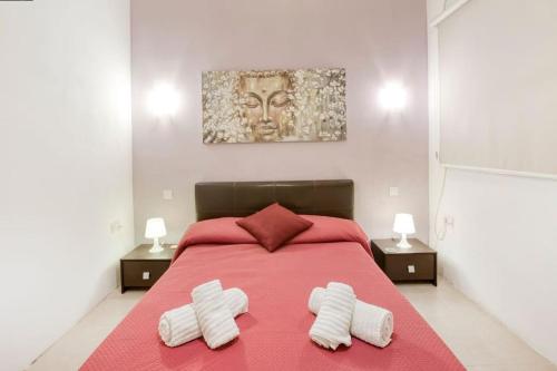 1 dormitorio con 1 cama grande de color rojo y 2 toallas blancas en Bright & Airy St. Julian's flat, en Il-Gżira