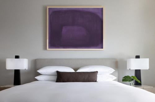 una camera da letto con un grande letto bianco con due lampade di Kimpton Claret Hotel, an IHG Hotel a Denver