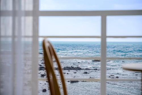a view of the ocean from a window at On The Sea Pension in Jeju