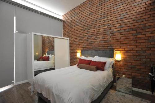 a bedroom with a brick wall and a large bed at Serviced apartments in Eros in Windhoek