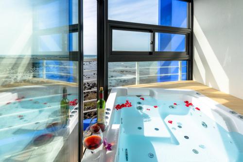 1 dormitorio con bañera frente a una ventana en On The Sea Pension en Jeju