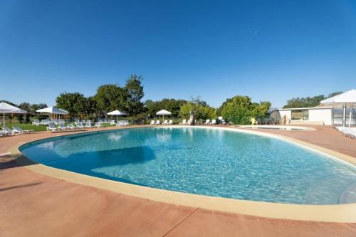 une grande piscine avec des chaises et des parasols dans l'établissement Mobilhome 3 étoiles - ef0a0h, à Rocamadour