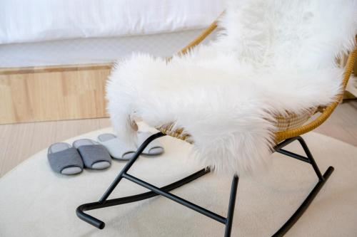 a white dog sitting on a chair in a room at On The Sea Pension in Jeju