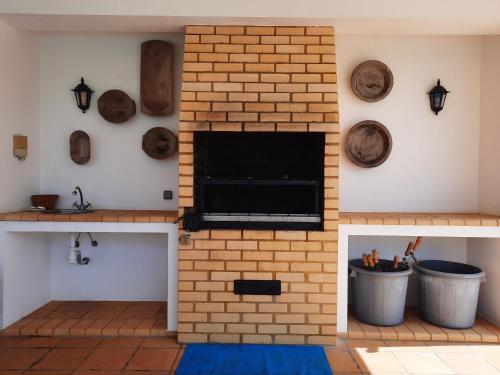 a fireplace in a living room with a brick wall at Tranquilidade Alentejana in São Cristóvão