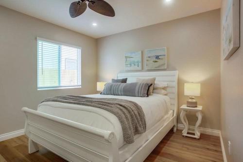 a white bedroom with a bed and a ceiling fan at Brighton Beach in San Diego