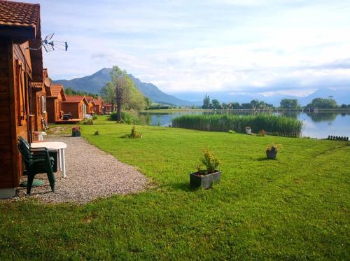 a grassy yard with a table and a view of a lake at Chalet 2 étoiles - ef0bde in Neffes
