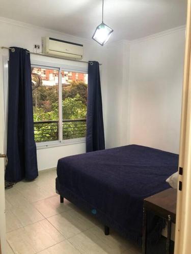 - une chambre avec un lit bleu et une fenêtre dans l'établissement Amplio y luminoso apartamento., à Buenos Aires