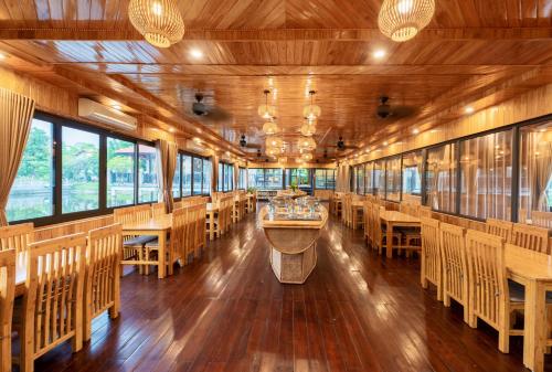 una sala da pranzo con tavoli e sedie in legno di Memorina Ninh Binh Resort a Ninh Binh