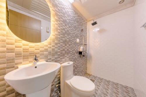 a bathroom with a sink and a toilet and a mirror at On The Sea Pension in Jeju