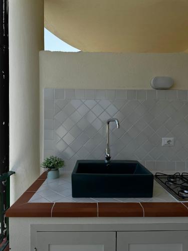 a kitchen with a green sink and a stove at Ohana Holiday in San Nicola Arcella