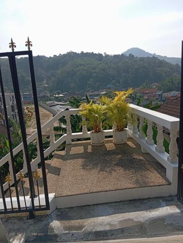 a white railing with potted plants on a balcony at Castle Villa Phuket in Kamala Beach