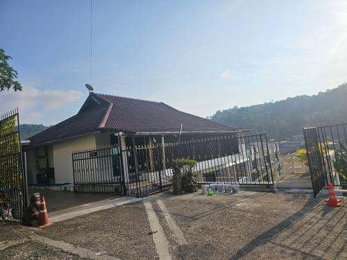 a building with a gate and a house with a mountain at Castle Villa Phuket in Kamala Beach