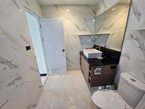 a bathroom with a sink and a toilet and a mirror at Castle Villa Phuket in Kamala Beach