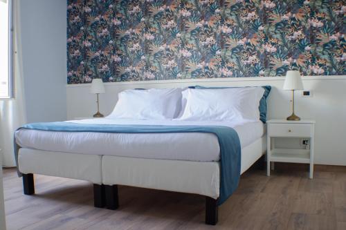 Schlafzimmer mit einem Bett mit Blumentapete in der Unterkunft Il Piccolo Eden in Pontinia