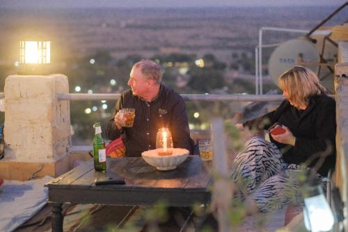 un hombre y una mujer sentados en una mesa con una vela en Sagar Guest House, en Jaisalmer