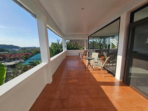 einen Balkon mit einem Tisch und Stühlen darauf in der Unterkunft Castle Villa Phuket in Kamala Beach