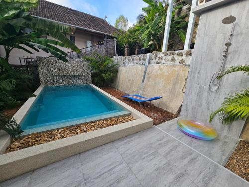 a swimming pool in a yard with a frisbee at Castle Villa Phuket in Kamala Beach
